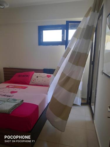 ein kleines Schlafzimmer mit einem Bett und einem Fenster in der Unterkunft Grand hills North Coast - Families Only z44 in Dawwār ‘Abd Allāh
