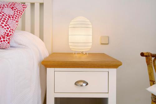a bedside table with a lamp on it next to a bed at Free Airport Shuttle and Parking in San Bartolomé de Tirajana