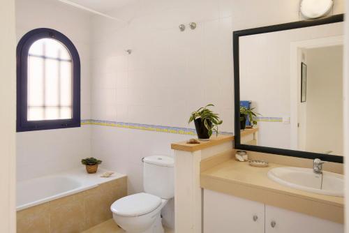 a bathroom with a toilet and a sink and a mirror at Free Airport Shuttle and Parking in San Bartolomé de Tirajana