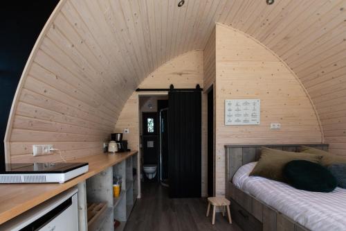 een kamer met een bed en een wastafel in een kamer bij Pod huisje met hottub in Dokkum