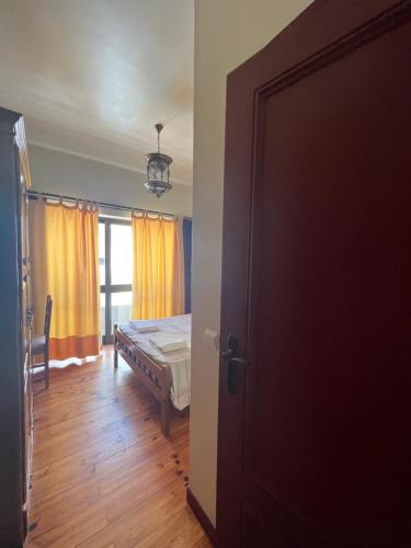 a bedroom with a bed and a window and a door at Abrigo and Restaurant Portinho in Vila Praia de Âncora