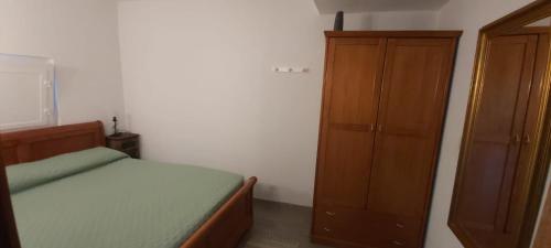 a bedroom with a bed and a wooden cabinet at Casa Oliveiras - Casas do Sinhel in Alvares