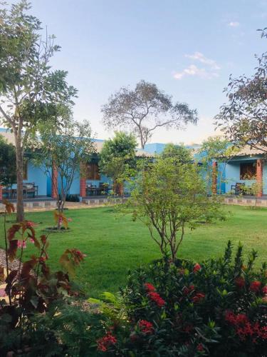 帕爾馬斯的住宿－Pousada Sambaíba，绿树成荫的庭院和蓝色的建筑