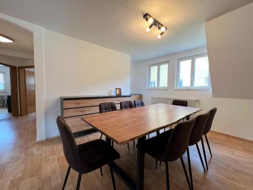 a dining room with a wooden table and chairs at Ferienwohnung Kinzigblick - Balkon - Für Kinder - mit Bettwäsche & Handtücher in Schenkenzell
