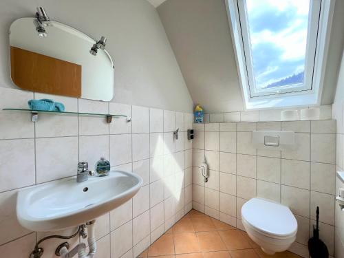 a bathroom with a sink and a toilet at Ferienwohnung Kinzigblick - Balkon - Für Kinder - mit Bettwäsche & Handtücher in Schenkenzell