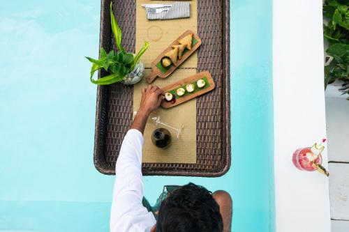 Een man reikt naar een koffer die tegen een muur hangt. bij Upendo Beach Boutique Hotel Zanzibar in Michamvi