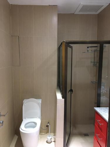 a bathroom with a toilet and a glass shower at Bhan Towers Apartment in Suva
