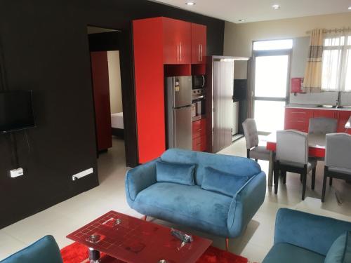 a living room with a blue couch and a kitchen at Bhan Towers Apartment in Suva