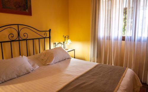 a bedroom with a bed with white sheets and a window at Hacienda Don Justo Hotel Boutique Spa in Colón