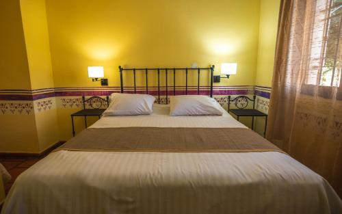 a bedroom with a large bed with two pillows at Hacienda Don Justo Hotel Boutique Spa in Colón