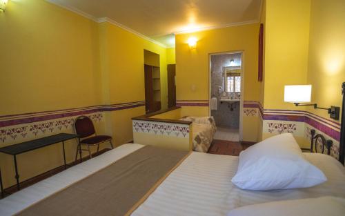 a bedroom with a bed and a desk and a mirror at Hacienda Don Justo Hotel Boutique Spa in Colón