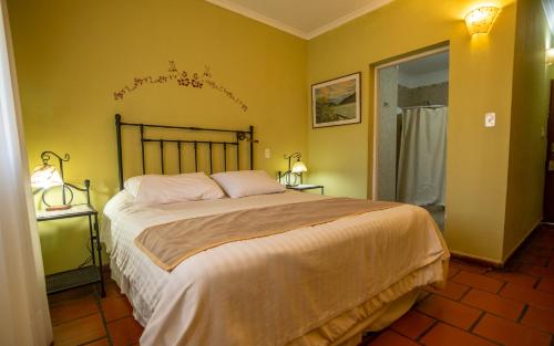 a bedroom with a large bed with yellow walls at Hacienda Don Justo Hotel Boutique Spa in Colón