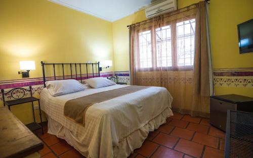 a bedroom with a bed and a window at Hacienda Don Justo Hotel Boutique Spa in Colón