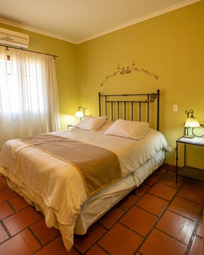 a bedroom with a large bed with yellow walls at Hacienda Don Justo Hotel Boutique Spa in Colón