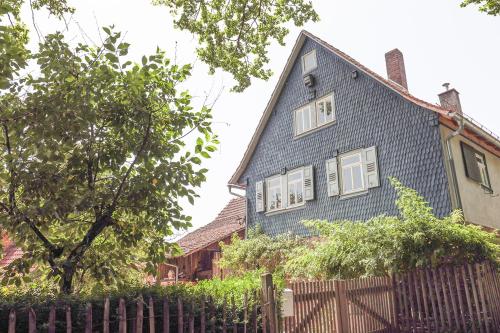 a blue house with white windows and a fence at Nibelungen Odenwaldhaus in Mossautal