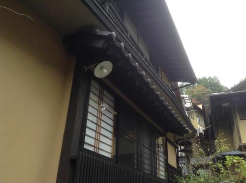a building with a window and a light on it at Fumoto Ryokan in Minamioguni