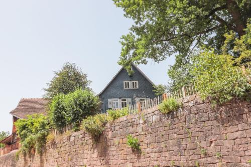 Una pared de ladrillo con una casa detrás. en Nibelungen Odenwaldhaus, en Mossautal