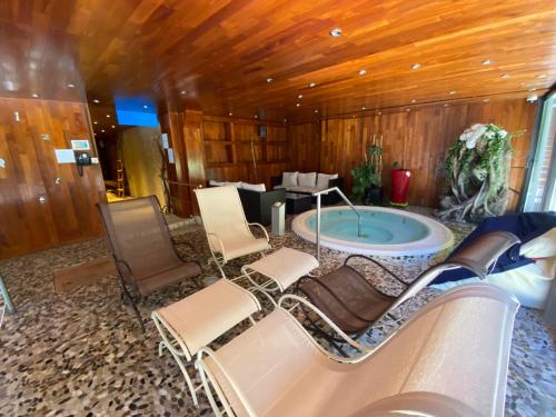 a room with a jacuzzi tub and chairs in a room at Hôtel Macchi Restaurant & Spa in Châtel