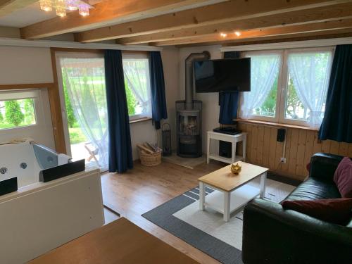 a living room with a couch and a tv at Chalet Hotel Adler in Kandersteg
