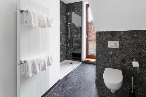 a black and white bathroom with a toilet and a shower at Ochsen Hotel Am Mehlsack in Ravensburg