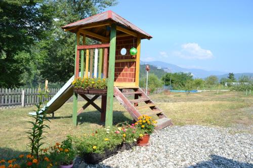 a small playground with a slide and some flowers at Drinski dragulj in Višegrad