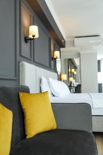 a bedroom with a bed with yellow pillows and a couch at FONTANA VERDE in Istanbul
