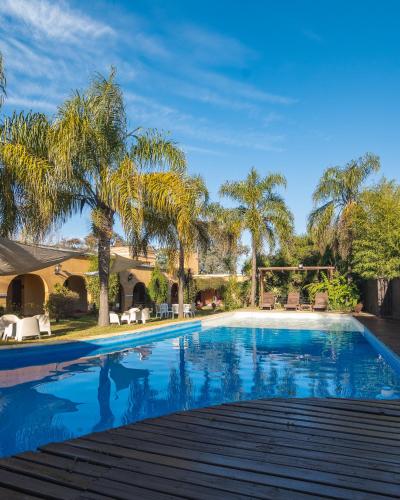 a swimming pool with palm trees and a house at Hacienda Don Justo Hotel Boutique Spa in Colón