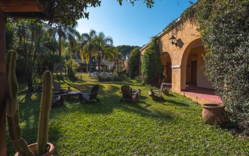 a yard with chairs and a table and a building at Hacienda Don Justo Hotel Boutique Spa in Colón
