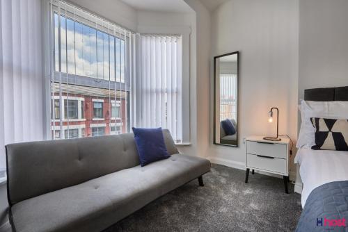 sala de estar con sofá, cama y ventana en Host Liverpool - Spacious Family Home by Aintree, Parking en Aintree