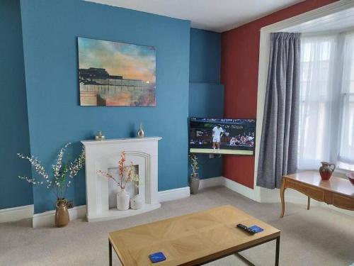 a living room with blue walls and a fireplace at Apartment 2, Aberystwyth Town Centre in Aberystwyth