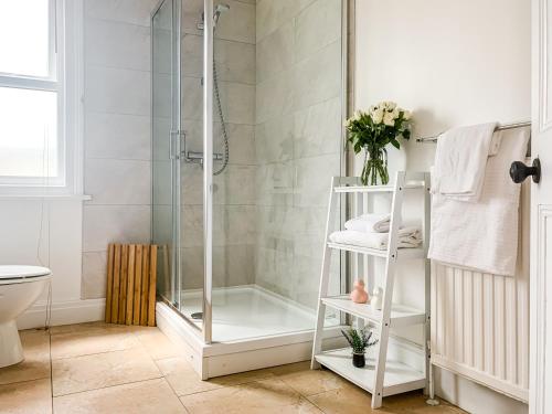 a bathroom with a shower with a glass door at Waverley Lodge - Quaint Victorian Home With Free Parking in York