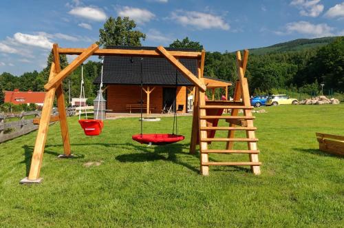 a playground with a swing set and a ladder at Przystanek Śnieżka in Kowary