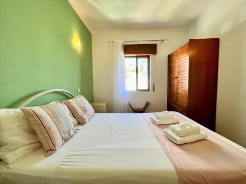 a bedroom with a large bed with two towels on it at Albufeira Classic 2 by Homing in Albufeira