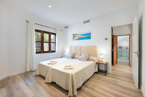 a white bedroom with a large bed in a room at Albercutx Pollentia 1 in Port de Pollensa