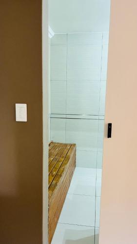 a glass shower with a wooden bench in a room at Stay at 11 on Gull in Cape Town