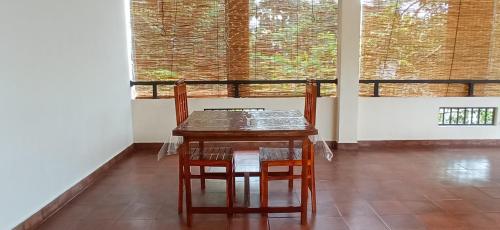 - une table et des chaises dans une chambre avec fenêtre dans l'établissement Me-Family, à Matale