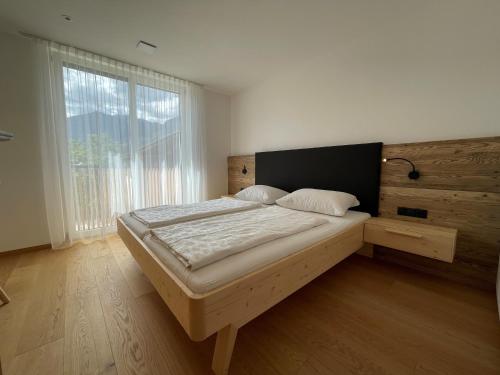 1 cama en un dormitorio con ventana grande en Mesnerhof Chalet en Bressanone