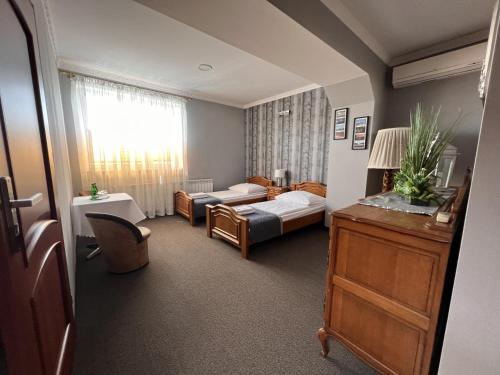 ein Wohnzimmer mit einem Bett und einem Sofa in der Unterkunft Noclegi-Restauracja Boss in Mogilno