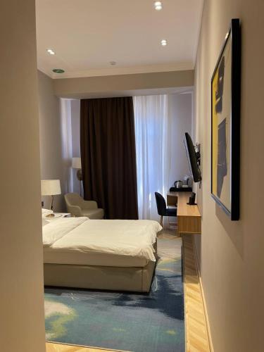 a hotel room with a bed and a desk at Termez Palace Hotel & Spa in Termiz