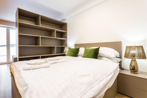 a bedroom with a large white bed with shelves at Klínovec-Apartments in Loučná pod Klínovcem