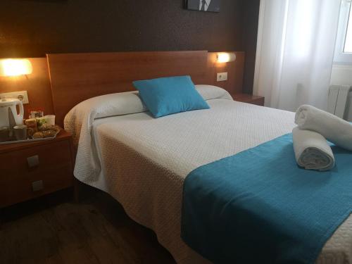 a hotel room with two beds with blue pillows at Hostería VISTAPARK in El Astillero