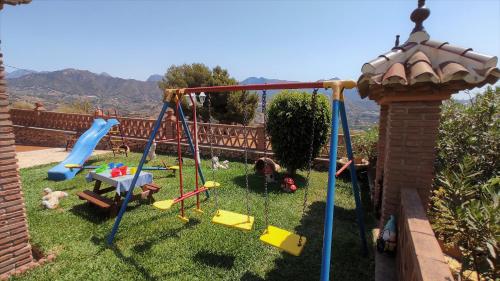 a yard with a swing set in the grass at Villa privada para familias in Torrox