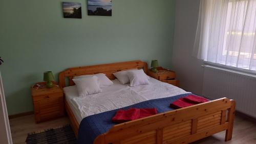 ケストヘイにあるZámor Nyaralóのベッドルーム1室(木製ベッド1台、ナイトスタンド2台付)
