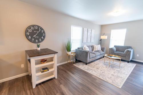 a living room with a clock on the wall at Susitna Suites in Wasilla