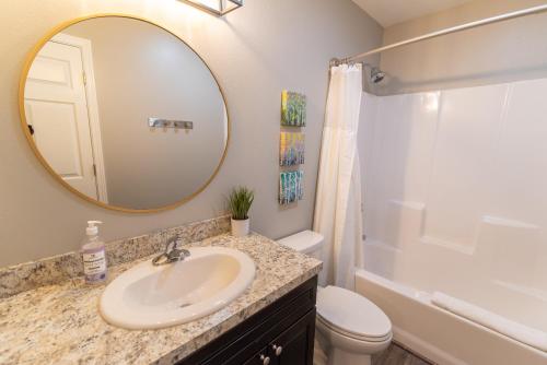 a bathroom with a sink and a toilet and a mirror at Susitna Suites in Wasilla