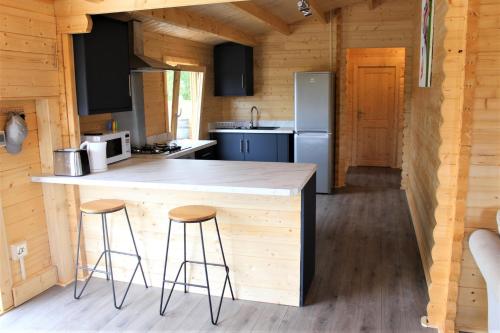 a kitchen with a counter and stools in a cabin at Stunning 5-Bed Cabin in Ashton Under Hill in Evesham