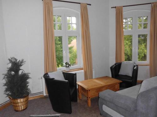 a living room with a couch and chairs and windows at Gutshaus Wohlenhagen in Wohlenberg