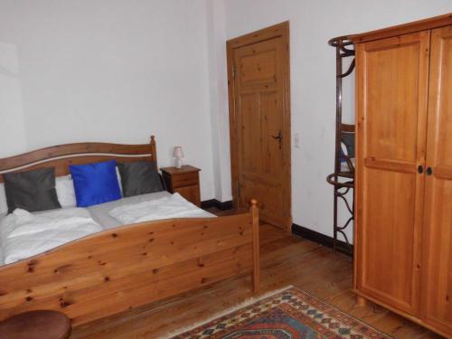 a bedroom with a wooden bed with a blue pillow at Gutshaus Wohlenhagen in Wohlenberg
