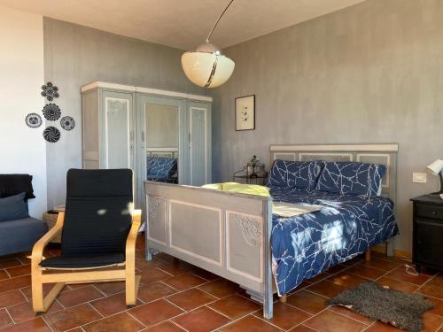 sypialnia z łóżkiem i krzesłem w obiekcie Piccolo Nido in Alta Langa /Cosy Studio w mieście Levice