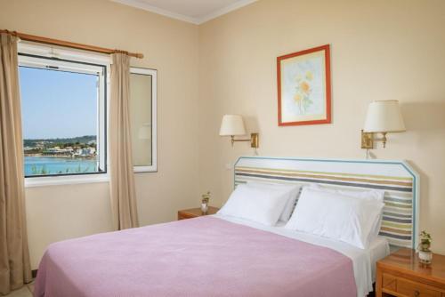 Un dormitorio con una cama grande y una ventana en Bella Vista Sea View Apartments, en Tragaki